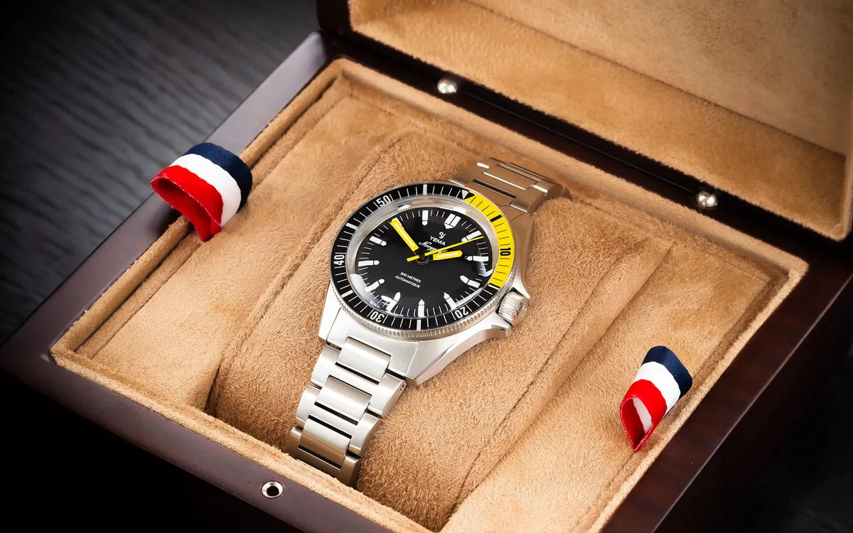 Yema Navygraf CMM.10 noire et jaune — montre présentée dans un écrin en bois