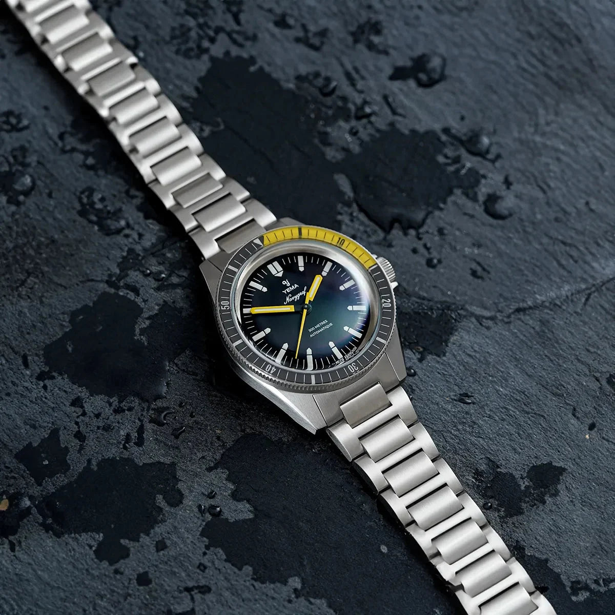 Yema Navygraf CMM.10 noire et jaune — montre posée sur un support nautique